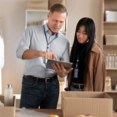 Couple reviews moving boxes together while settling into their home.